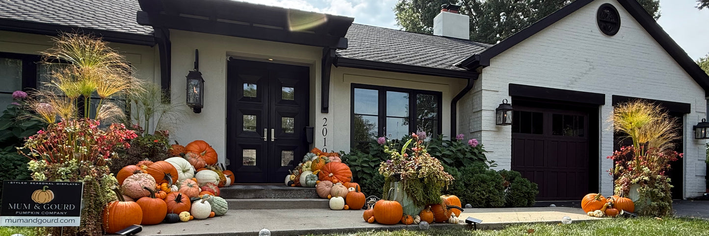 a grand Kansas City porch display featuring stacked pumkins and gourds with straw bales arranged by Mum & Gourd