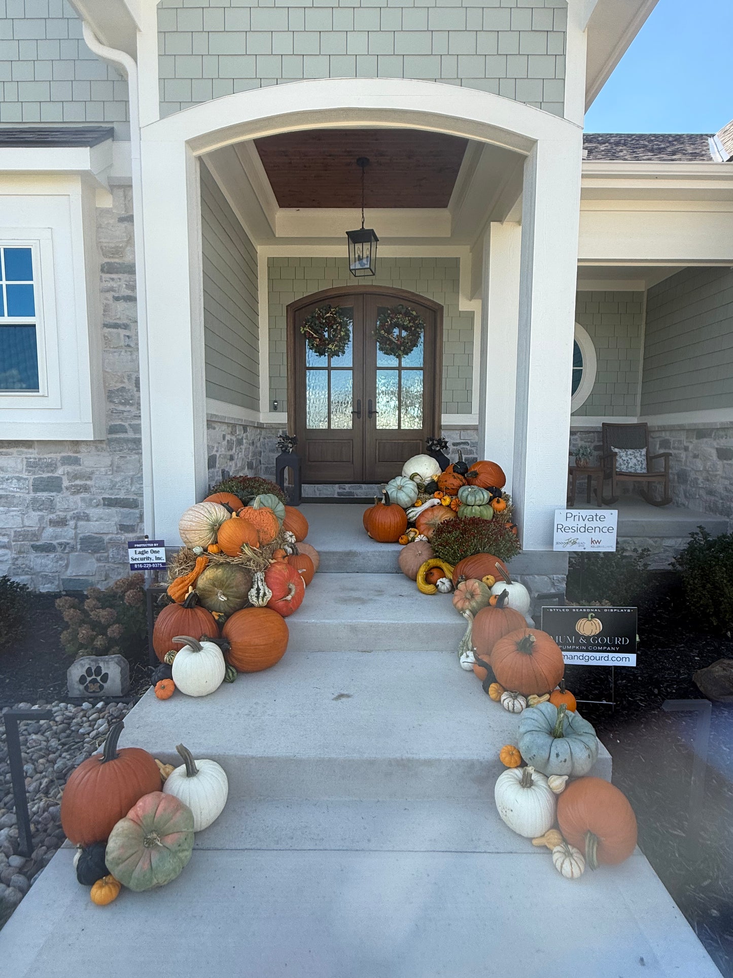wide angle view of Kansas City fall pumpkin display residential front porch in layered varities of pumpkins